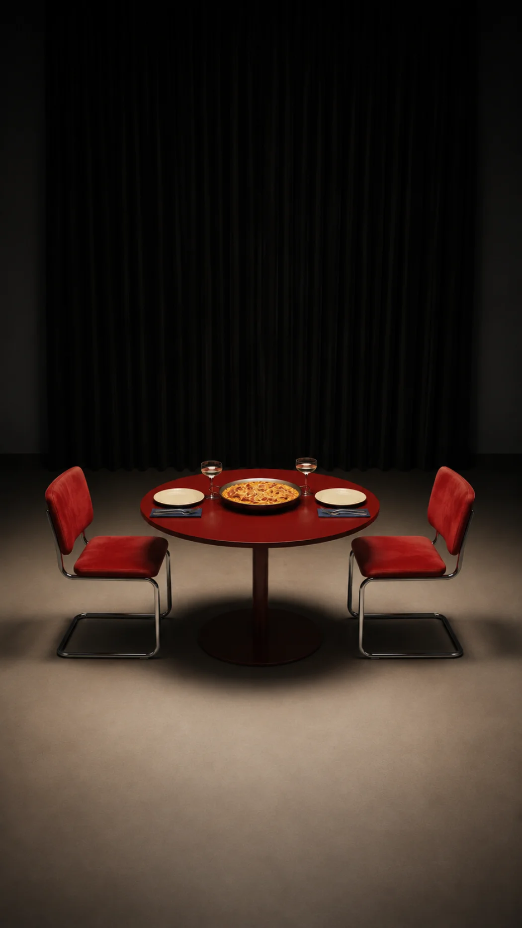 Mesa con una paella servida entre dos sillas rojas